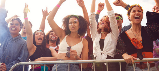 Cheering Young Friends In Audience Behind Barrier At Outdoor Festival Enjoying Music Cheering Young Friends In Audience Behind Barrier At Outdoor Festival Enjoying Music